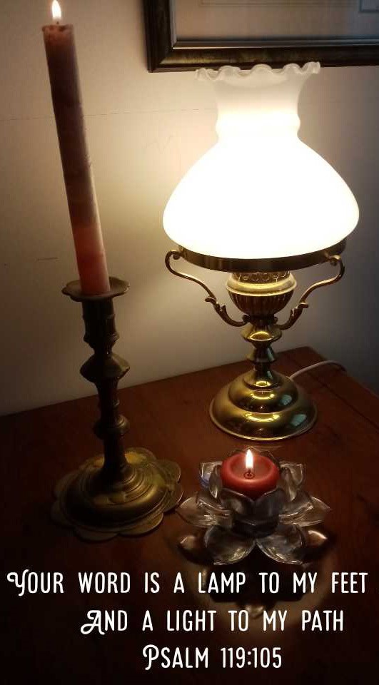 a picture of 2 candles in holders and an electric lamp on a table with
a quotation from Psalm 119:105